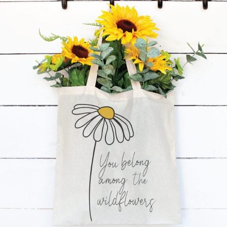 White tote bag with a wildflower design that says, You Belong Among the Wildflowers
