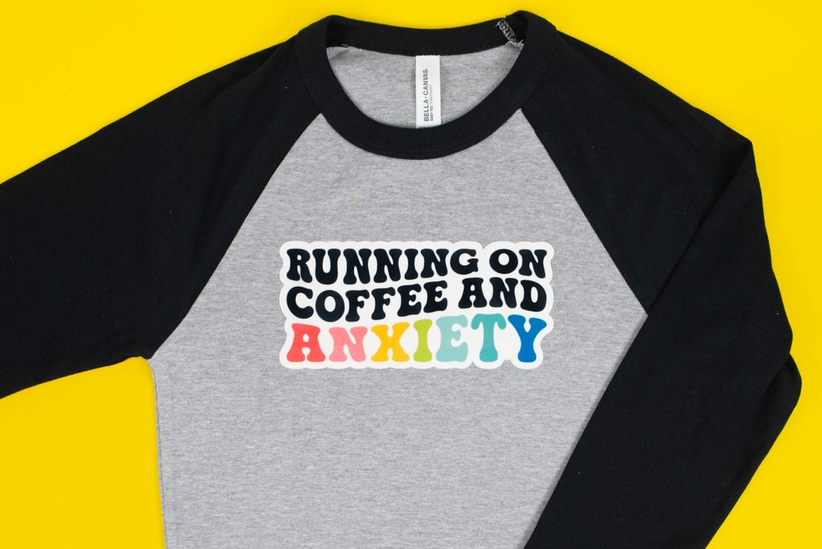 "Running on Coffee and Anxiety" image on SubliFlock on gray and black baby tee