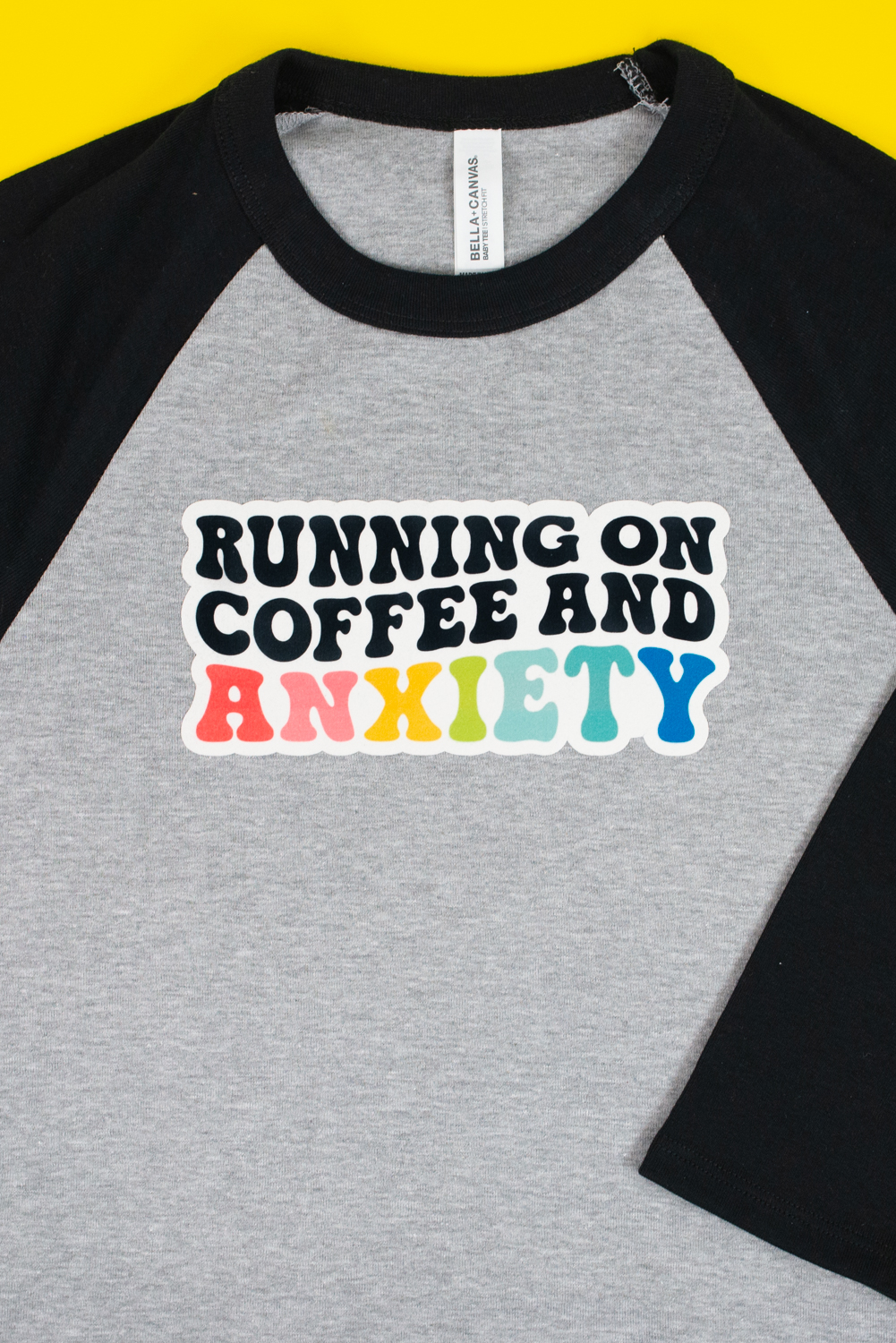 "Running on Coffee and Anxiety" image on SubliFlock on gray and black baby tee