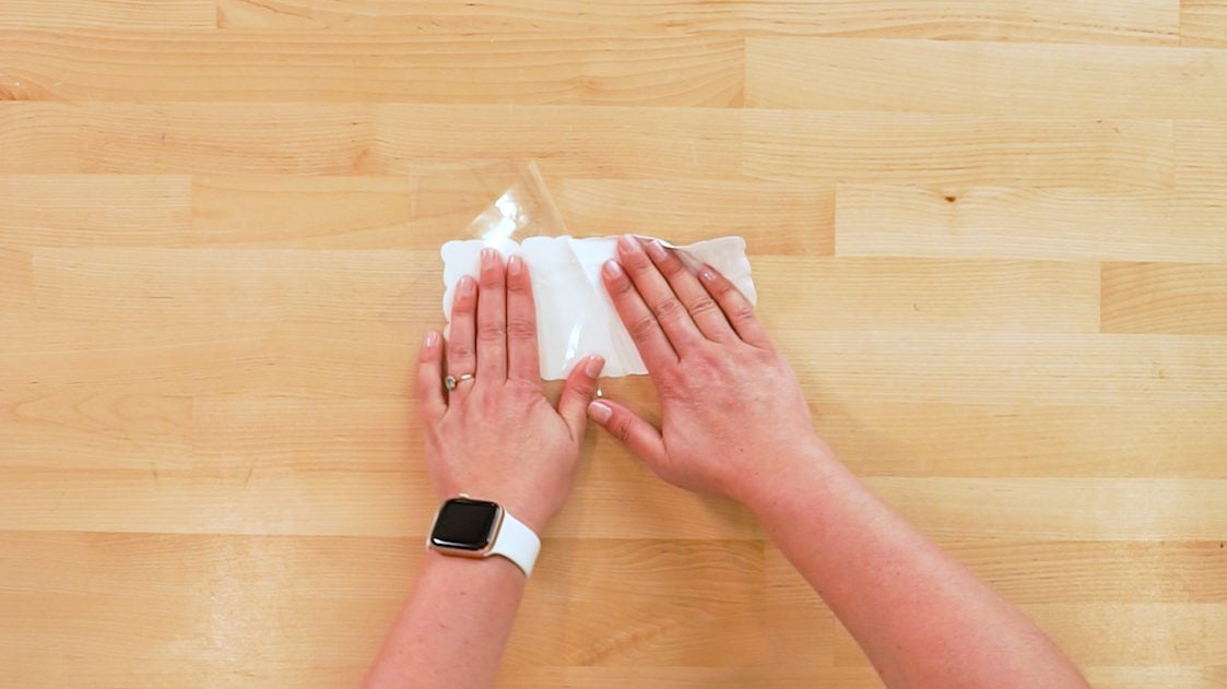 Hands peeling the SubliFlock image off the carrier sheet