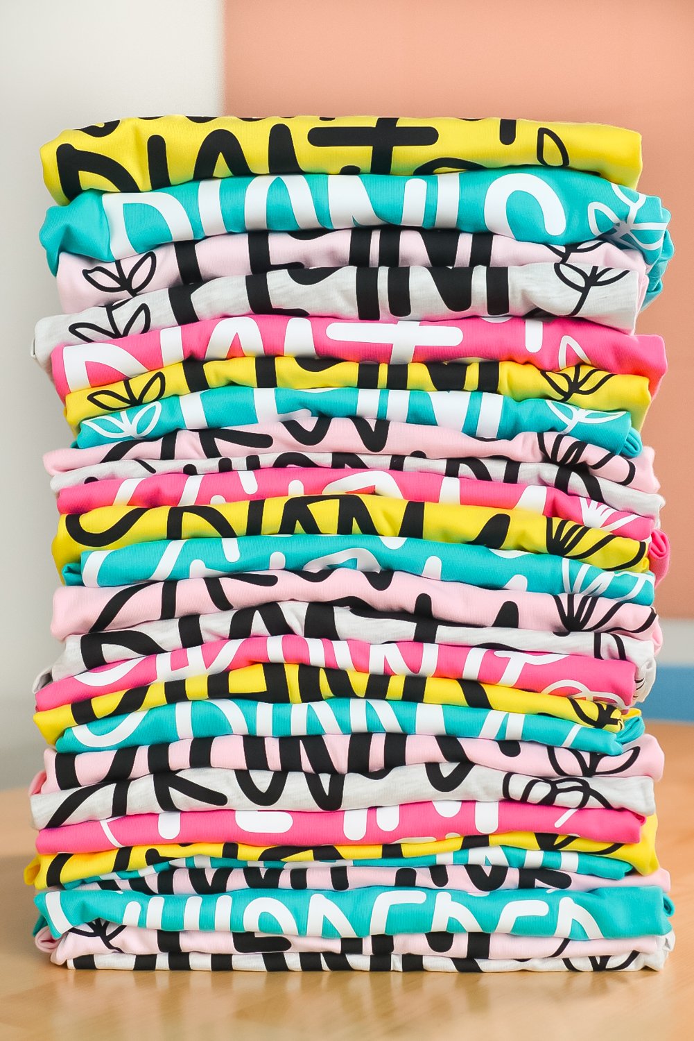 Batching crafts: stack of colorful shirts made with Cricut Venture