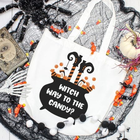 Tote bag with a black cauldron on it and the saying Witch Way to the Candy