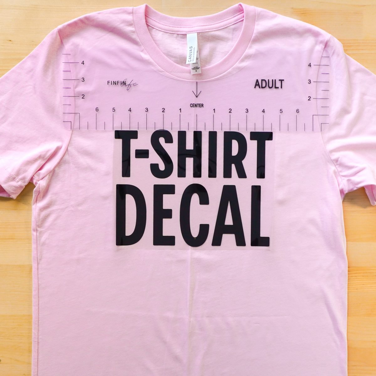 Pink t-shirt with decal and plastic ruler