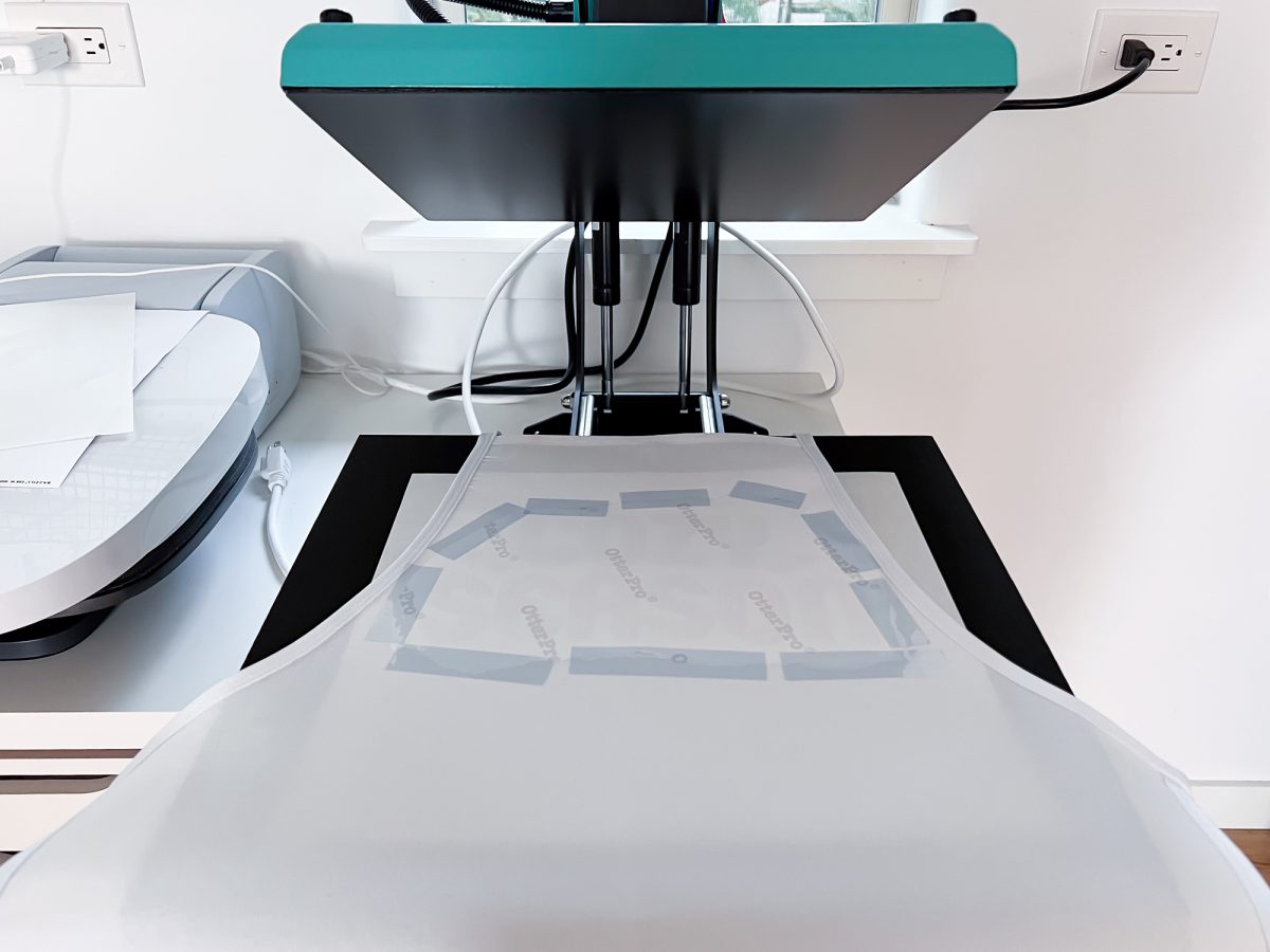 Open heat press with apron inside