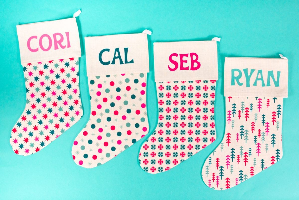 Four patterned Christmas stockings on teal background