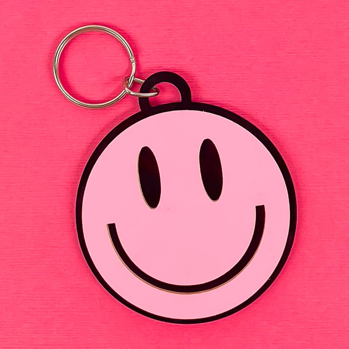Happy face keychain on pink background