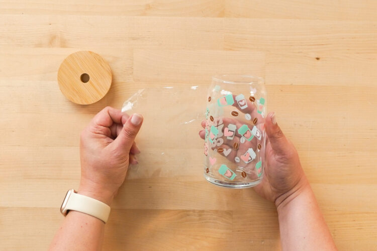 Hands peeling back the clear liner from a cup