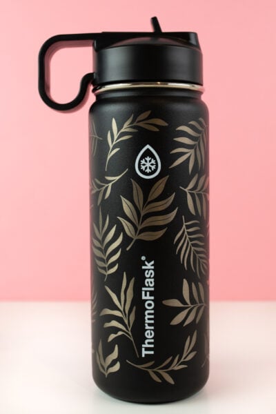 Final engraved tumbler with leaf design around the logos