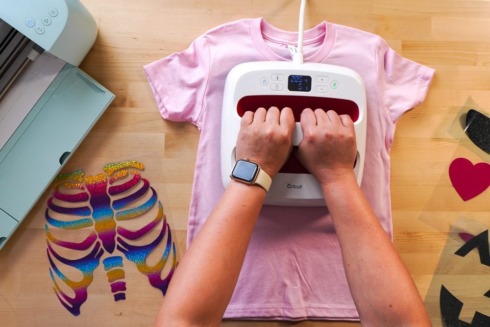 Hands pre-pressing the pink t-shirt