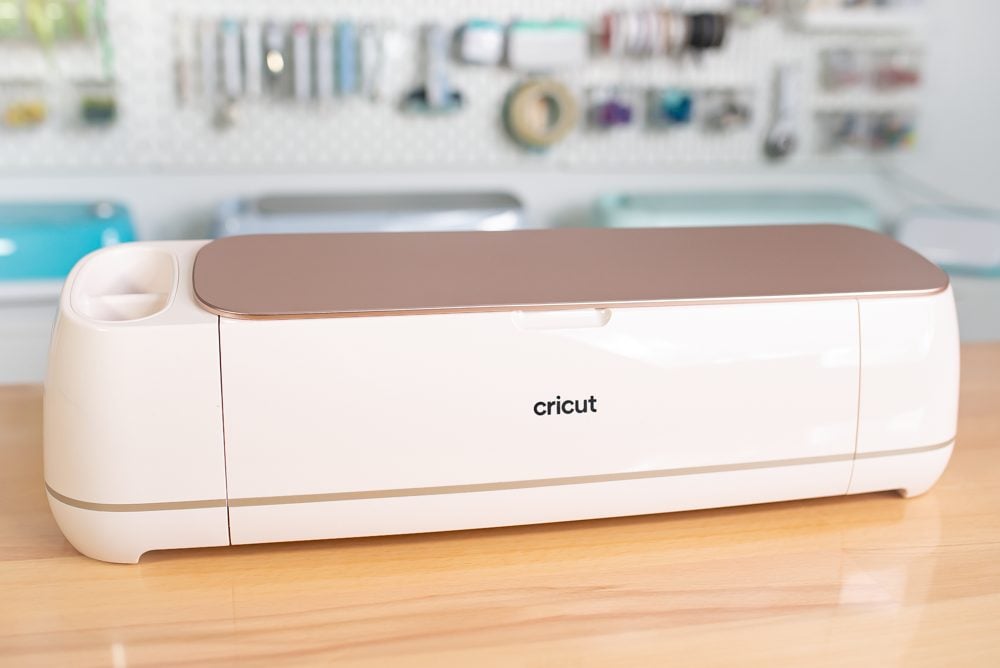 Cricut Maker 4 closed on a table with a peg board behind it.