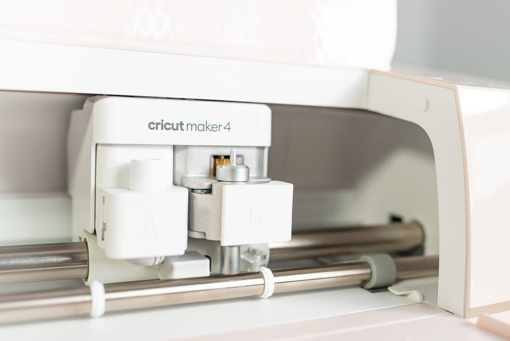 Cricut Maker 4 open on a table with a closeup of the carriage