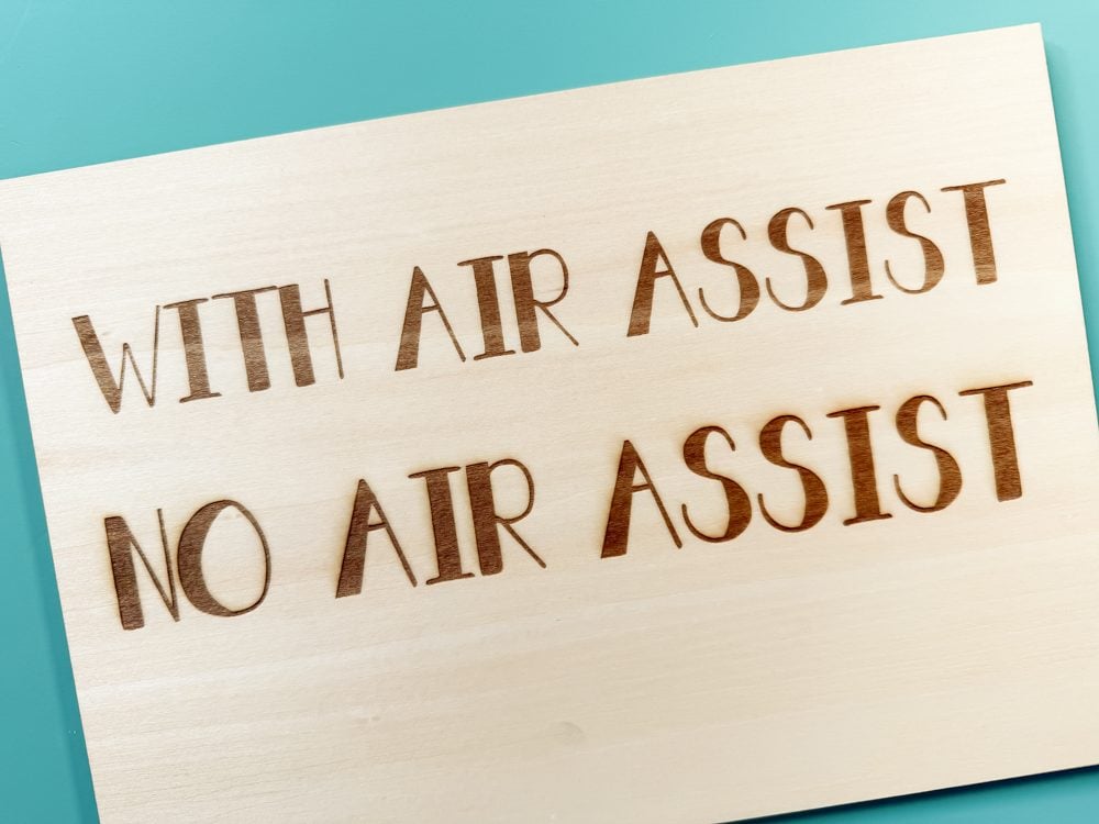 Piece of basswood with "with air assist" and "no air assist" engraved. No air assist has charring