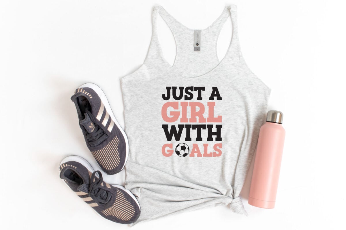 Just a Girl with Goals SVG on a gray athletic tank top with tumbler and tennis shoes