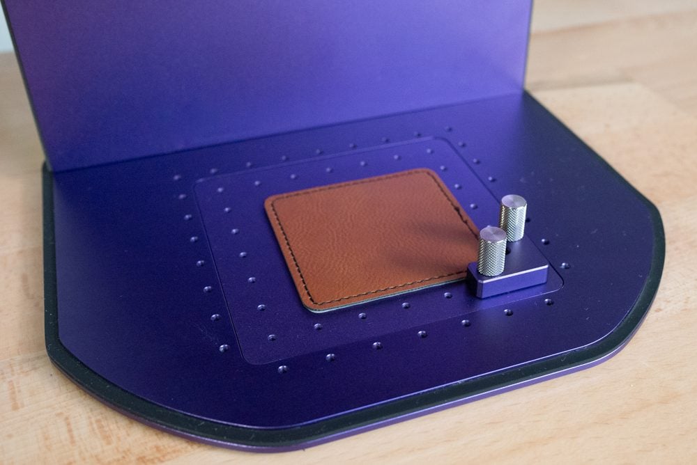 Closeup view of the WeCreat Lumos base plate for engraving, with the positioning pieces screwed in.