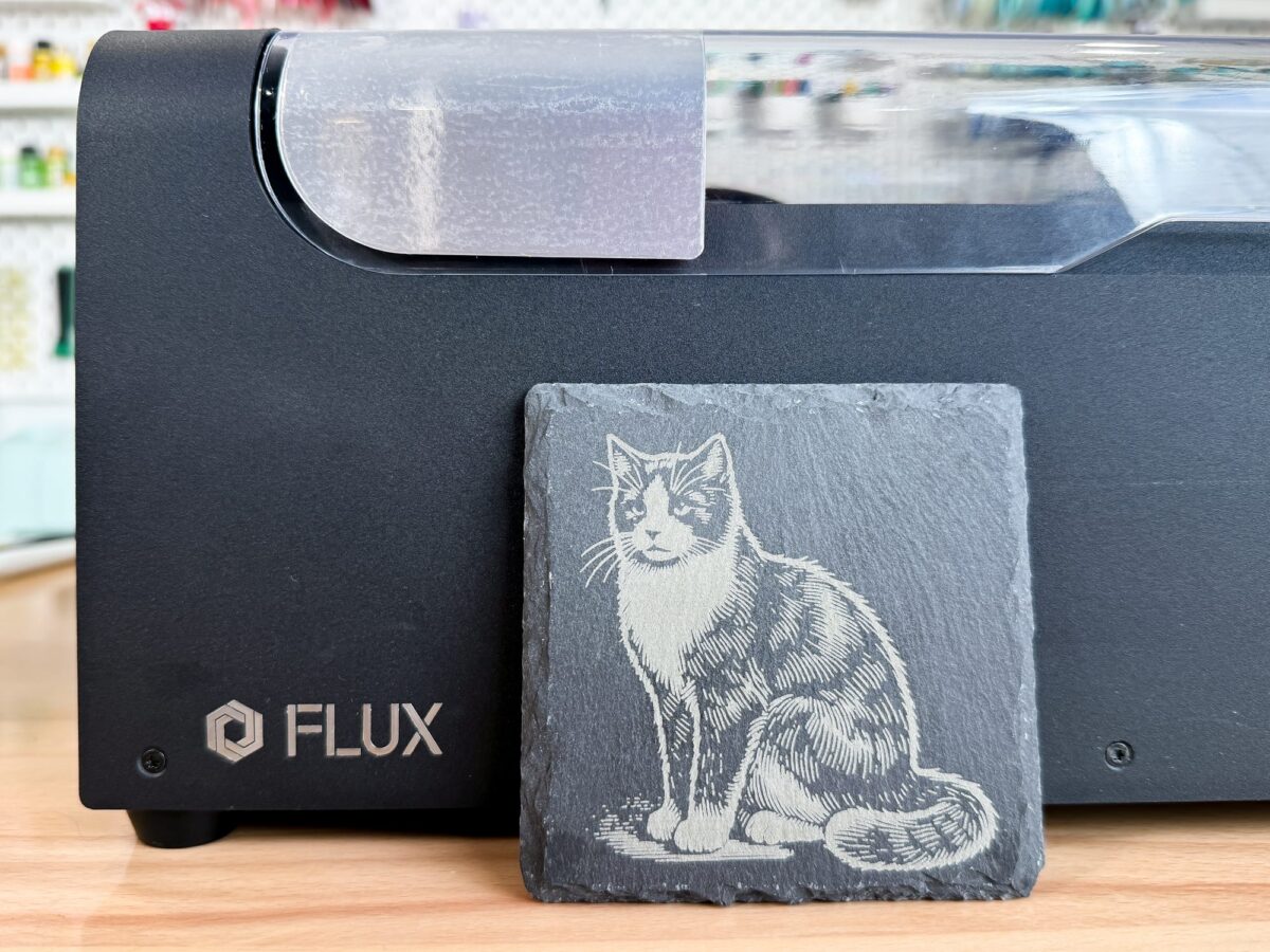 Cat engraved slate in front of the FLUX beamo