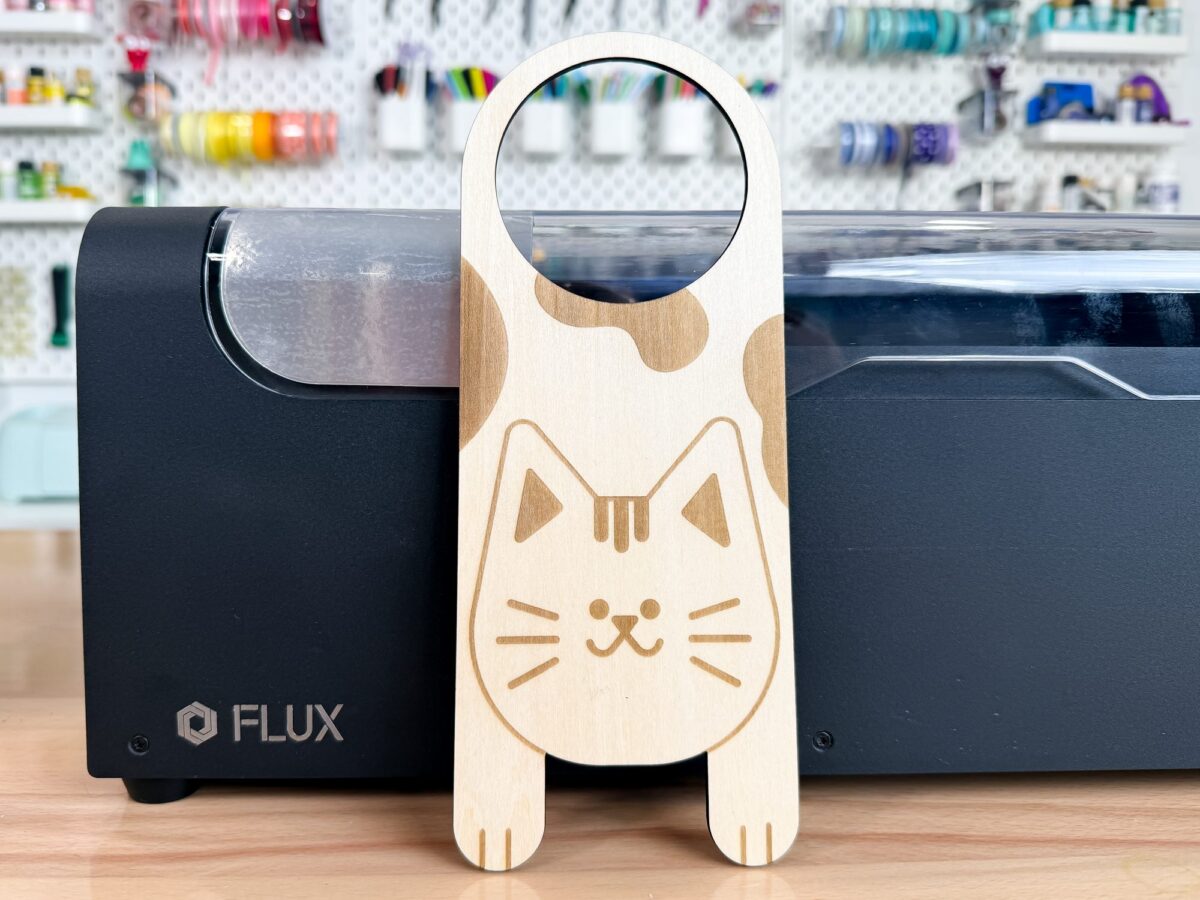 Cat door hanger made out of basswood in front of the FLUX beamo