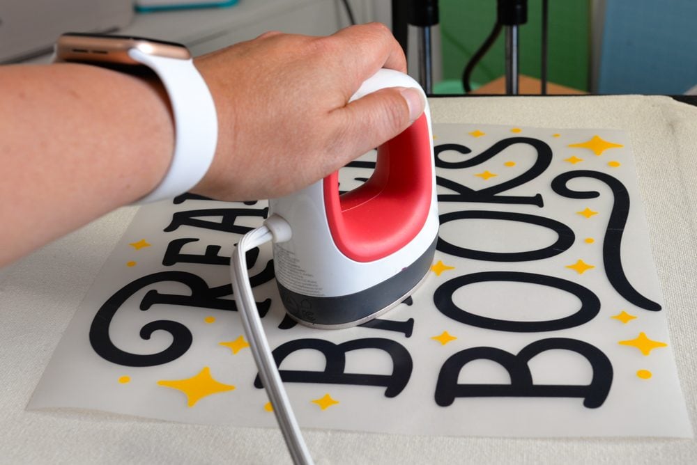 Hand using mini press to spot press transfer