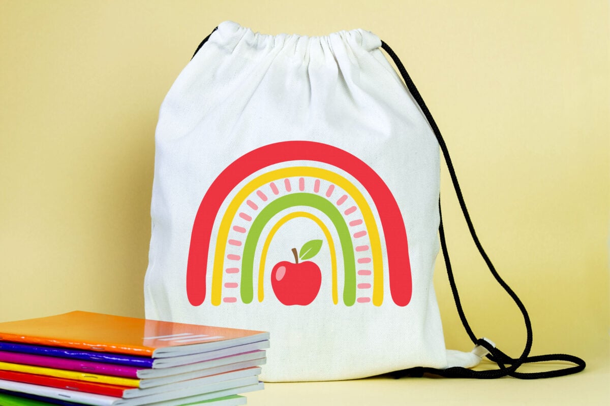 Apple Rainbow SVG on a backpack with school supplies