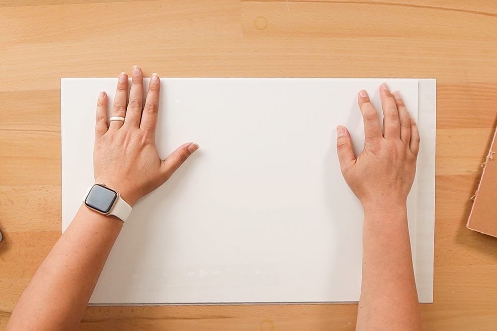 Hands adhering the acrylic to the adhesive