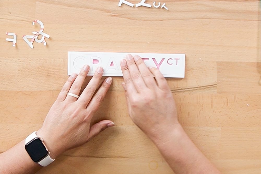 Hands assembling the letters