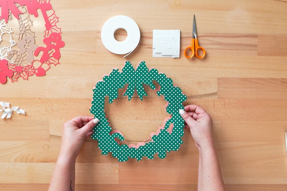 Hands applying the green layer to the pink layer