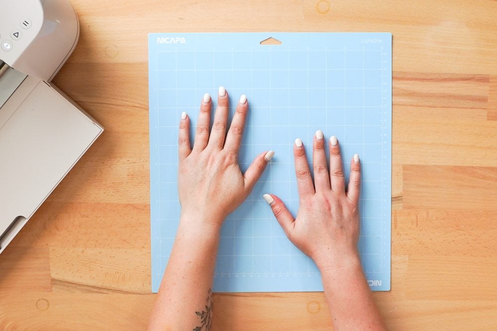 Hands pressing the blue mat to prime it.