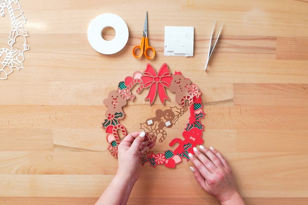 Hands applying the brown layer to the red layer