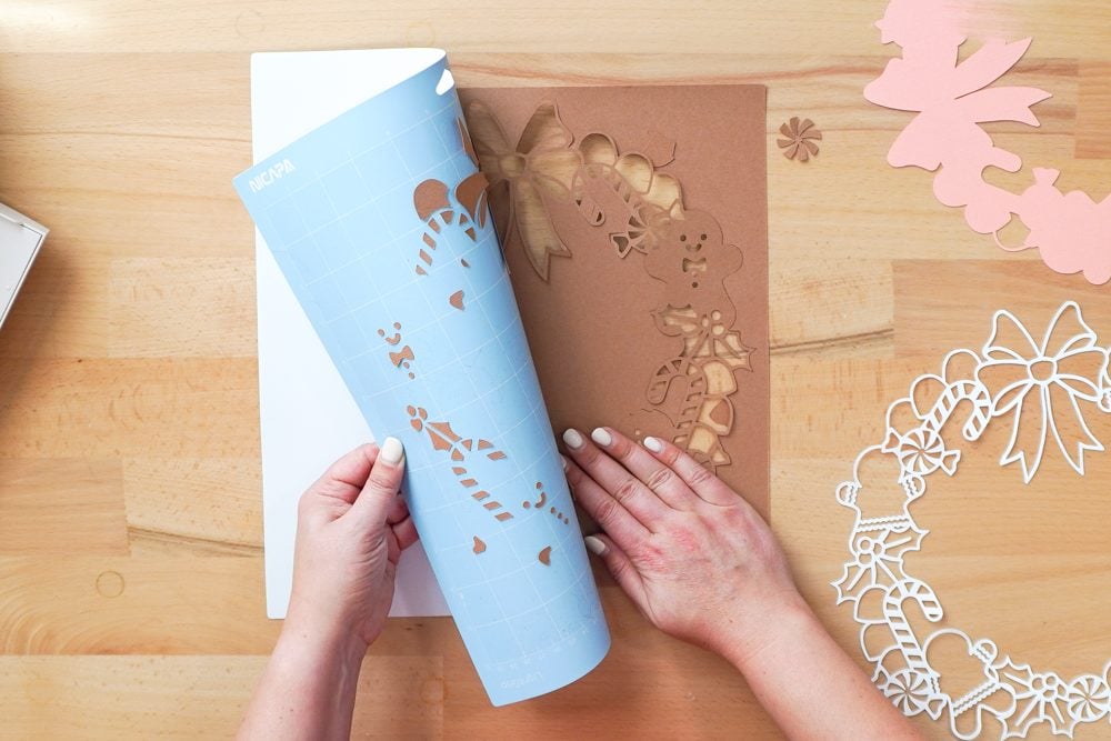 Hands removing the brown cardstock layer from the mat