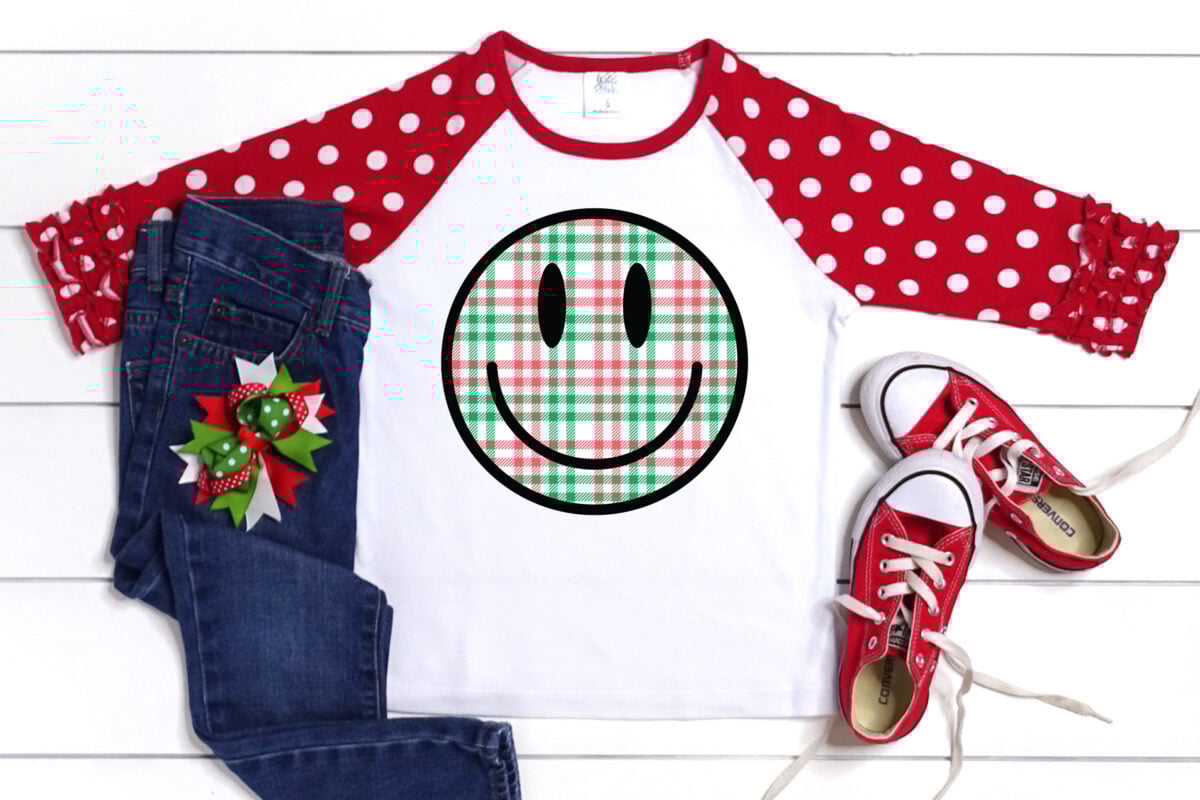 Christmas Happy Face sublimation file on a kids shirt with Christmas accessories