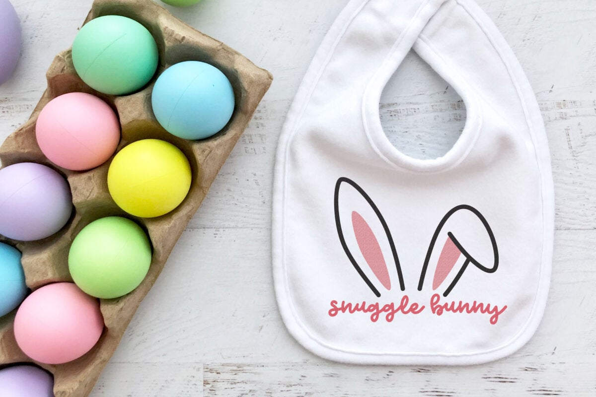 Free snuggle bunny SVG on a white bib with easter eggs