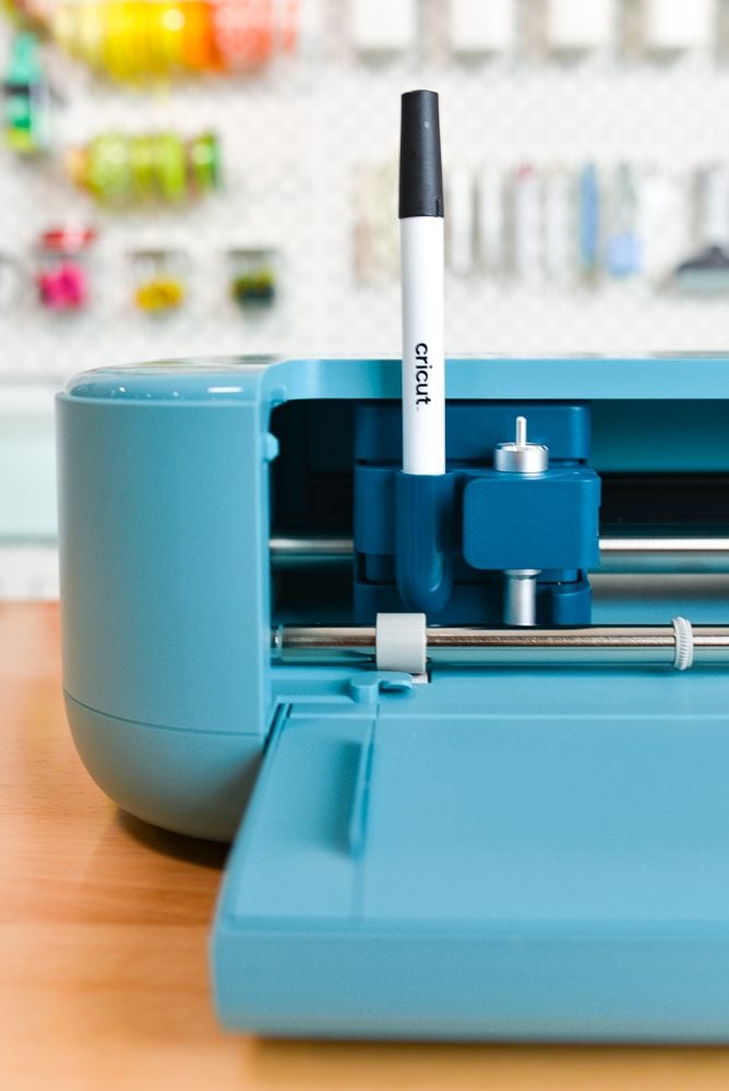 Cricut Explore 5 on a table, viewed from the front, up close with a pen in the adapter