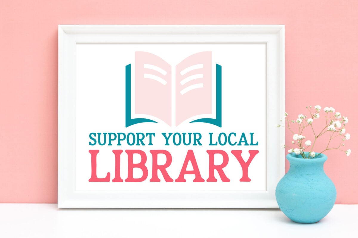Support Your Local Library SVG in a frame in front of a pink wall