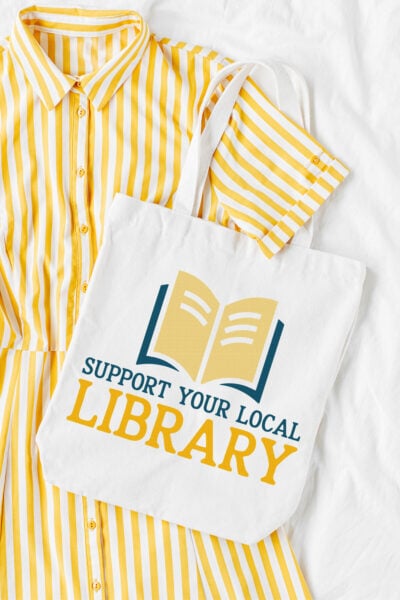 Support Your Local Library SVG on a tote bag with a yellow dress