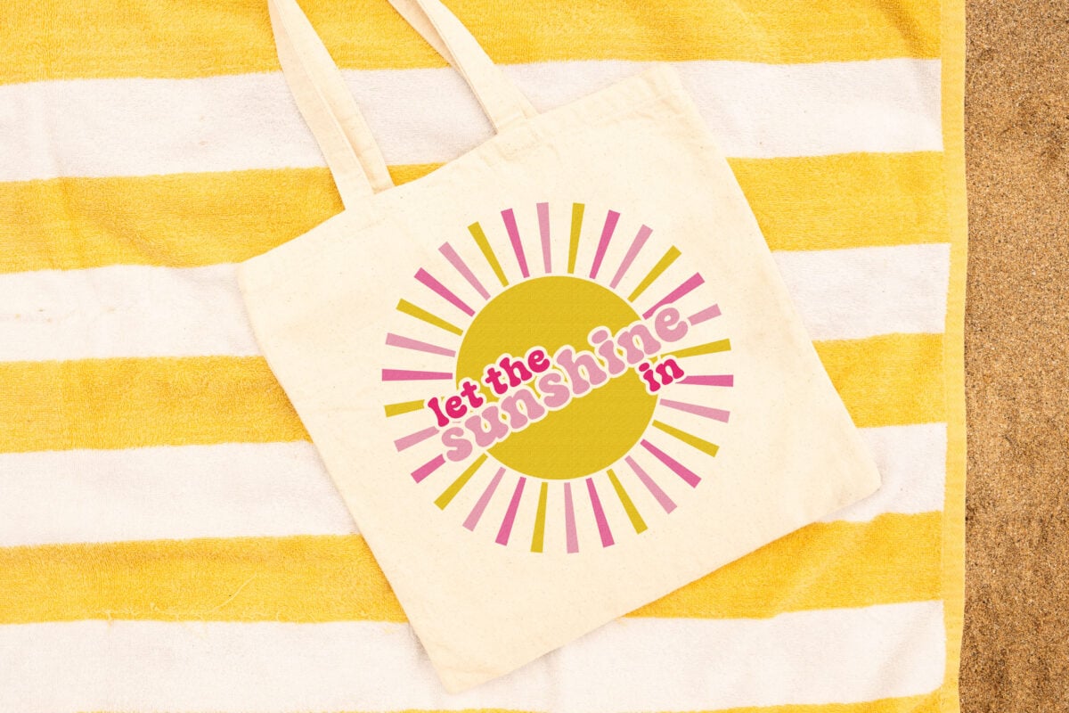 Free sunshine sublimation image on a tote bag on a striped yellow towel